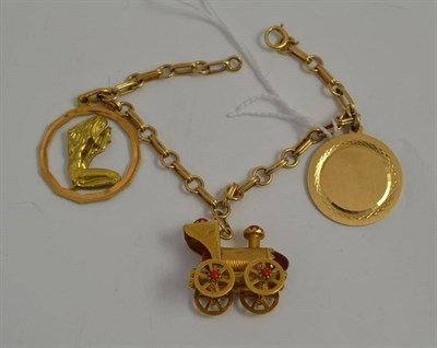 Lot 31 - A charm bracelet stamped '14KT' hung with three charms, one stamped '750', one stamped '14K'...