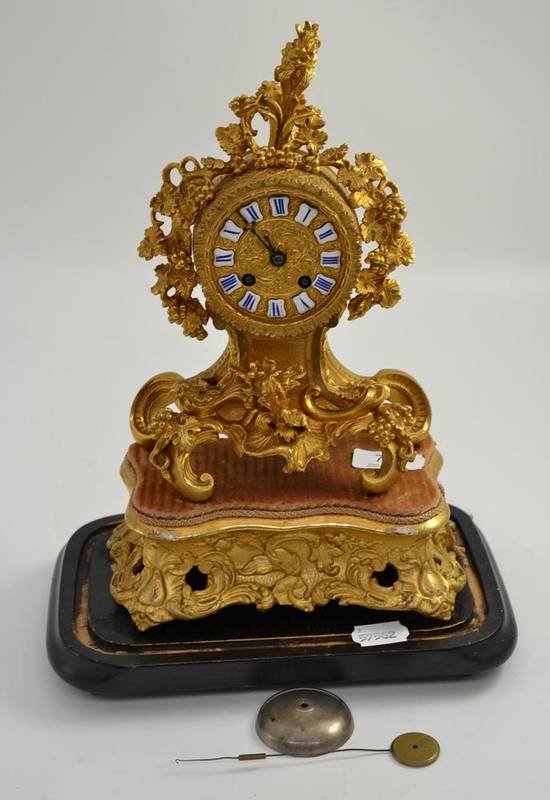Lot 74 - A French ormolu style gilt metal mantel clock with rococo scroll base and stand
