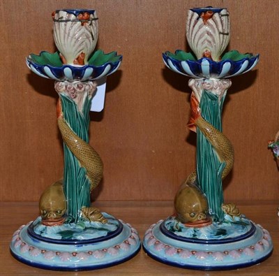 Lot 211 - A pair of Royal Worcester Majolica candlesticks, with stylised dolphins and shell motifs,...