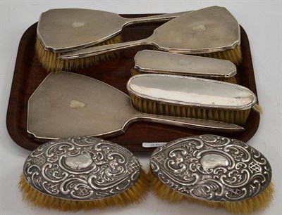 Lot 253 - A four piece silver dressing table set, a pair of silver backed brushes and another