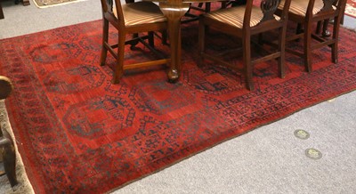 Lot 1163 - Afghan Carpet, the burgundy field with three...