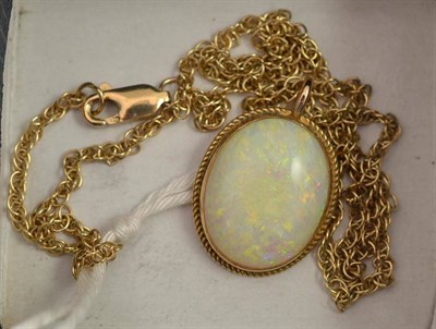 Lot 325 - A 9ct gold opal pendant on Chain, the oval cabochon opal within a rope twist border, measures 1.7cm