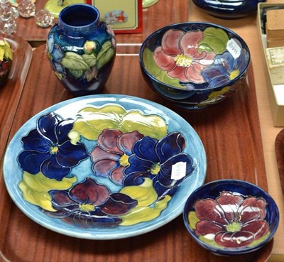 Lot 373 - Four pieces of Walter Moorcroft Clematis pattern; plate, 26cm wide, vase, 14cm, two bowls,...