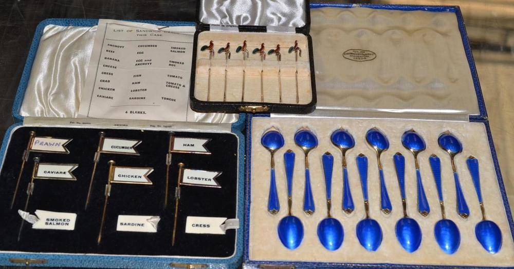 Lot 483 - A set of twelve cased enamel teaspoons, a