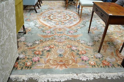 Lot 677 - Savonnerie design Carpet, China, the mint green field with floral medallion framed by spandrels and