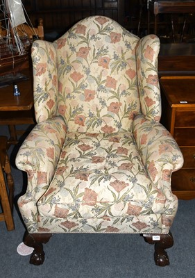 Lot 1289 - A George III Style Wing Back Chair, on claw on...