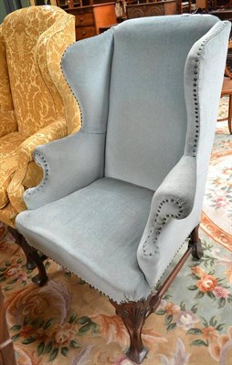 Lot 753 - An early 20th century wingback armchair with shell carved knees and blue upholstery