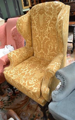 Lot 754 - An early 20th century wingback armchair with gold damask upholstery