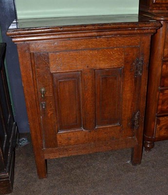 Lot 830 - An 18th century oak single door cupboard of joined construction enclosing a bank of ten drawers