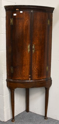 Lot 1320 - A George II Oak Bow-Front Corner Cupboard, on...