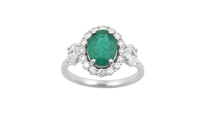 Lot 2230 - An Emerald and Diamond Cluster Ring the oval...