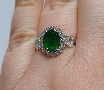 Lot 2230 - An Emerald and Diamond Cluster Ring the oval...