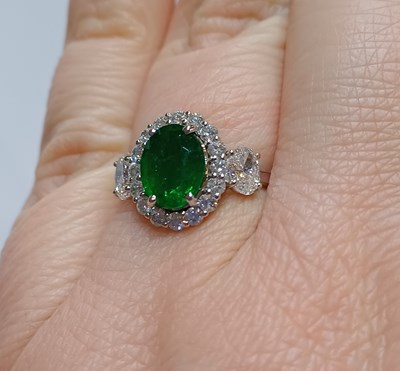 Lot 2230 - An Emerald and Diamond Cluster Ring the oval...