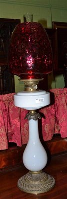 Lot 269 - Glass oil lamp with cranberry shade