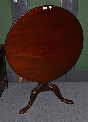 Lot 407 - A George III mahogany tripod table, late 18th century, the circular flip top raised on a bird...