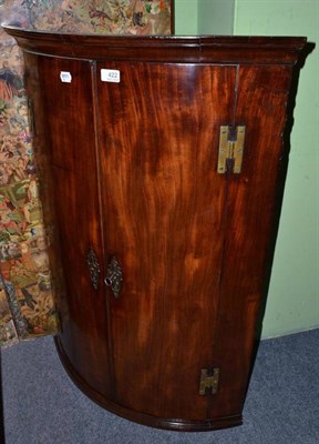 Lot 422 - A George III mahogany bow fronted corner cupboard