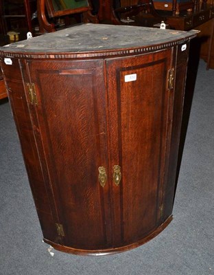 Lot 432 - An oak and mahogany bow fronted, crossbanded corner cupboard