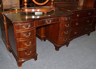 Lot 439 - Reproduction mahogany serpentine front desk with glass protector and mahogany three-height chest of