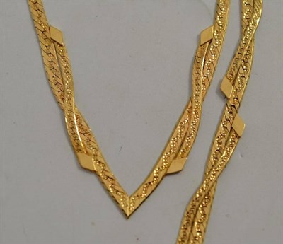 Lot 184 - A yellow metal flat crossover two strand bracelet and necklace, both stamped '750'