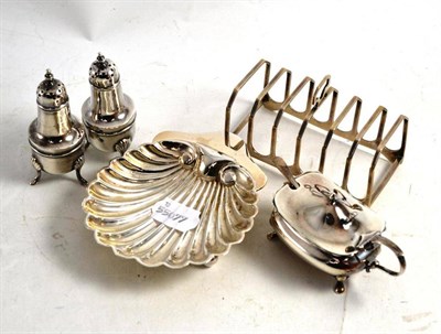 Lot 302 - A silver shell dish, silver toast rack, a pair of silver pepperettes, silver mustard and spoon