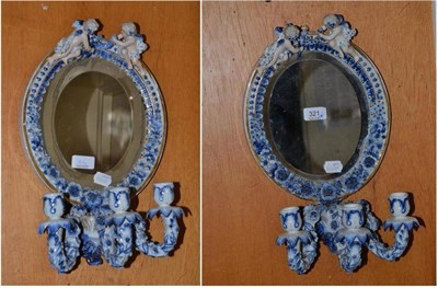 Lot 321 - A pair of Continental porcelain three branch girandoles, each mounted with two cherubs