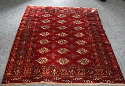 Lot 1236 - "Bukhara" Rug, the scarlet field with three...