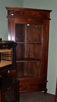 Lot 509 - A reproduction carved hard wood glazed floor standing corner cabinet