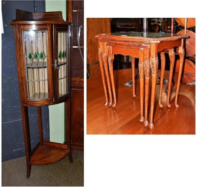 Lot 517 - An Edwardian corner cabinet with glazed doors and a nest of three tables