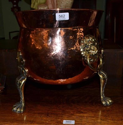 Lot 562 - Copper planter with lion mask handles on three brass feet