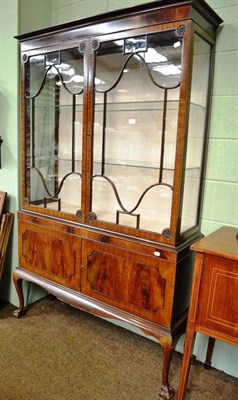 Lot 643 - A 20th century glazed mahogany display cabinet with double door cupboard base