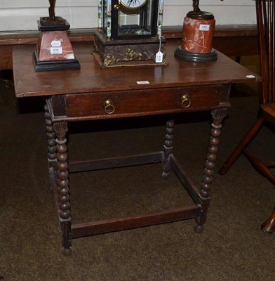 Lot 646 - An early 18th century oak side table, the four plank top with cleated ends above a frieze...