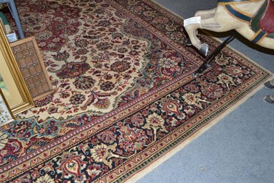 Lot 688 - Machine made carpet of Oriental design, the cream field centred by a pole medallion enclosed by...