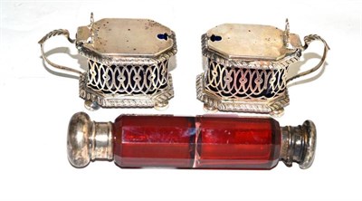 Lot 90 - A pair of silver mustards and a cranberry double scent bottle with silver lids