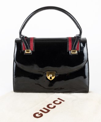 Lot 2181 - A Gucci Black Patent Leather Bag, gold toned...