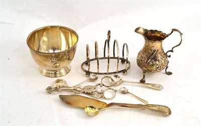 Lot 247 - A set of George III silver sugar tongs, a Georgian cream jug, a sugar bowl, toast rack, butter...