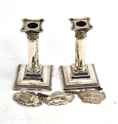 Lot 302 - A pair of silver candlesticks, silver wine label and two plated labels