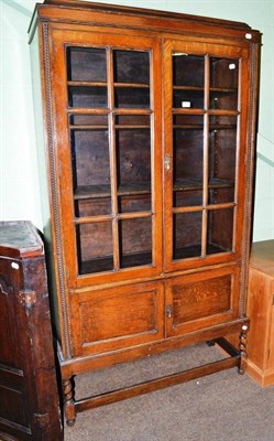 Lot 442 - A 1920's glazed oak display bookcase