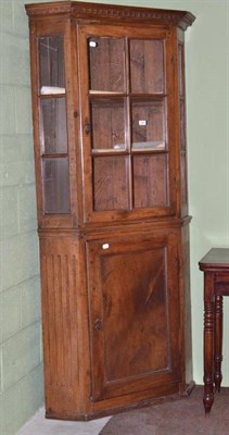 Lot 558 - A late 18th/early 19th century fruitwood floor standing corner cabinet with glazed upper section