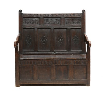 Lot 482 - A Carved Oak Box Settle, the fielded back...