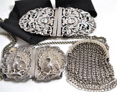 Lot 25 - A silver belt buckle, a white metal belt buckle and a purse