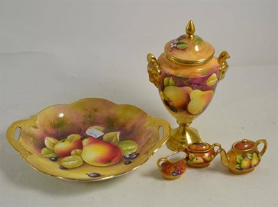Lot 94 - A Coalport fruit painted vase and cover, a three piece miniature tea set and a dish (5)