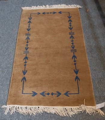 Lot 1279 - Nepalese Rug, the plain camel field with a...
