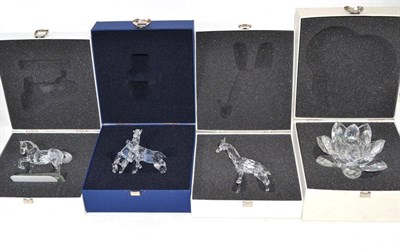 Lot 249 - Four Swarovski boxed ornaments - giraffe, flower/candle holder and two horses
