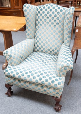 Lot 1239 - A George III Style Wingback Armchair, on claw...