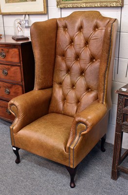Lot 1117 - A Modern Tan Leather Wing Armchair