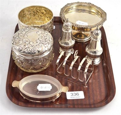 Lot 336 - A tray of silver items comprising a Victorian foliate embossed sugar bowl, a cut glass dressing...