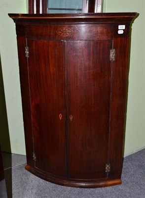 Lot 438 - A mahogany Georgian bow fronted corner cupboard