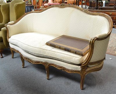 Lot 482 - A French style cream upholstered sofa with a painted gilt frame