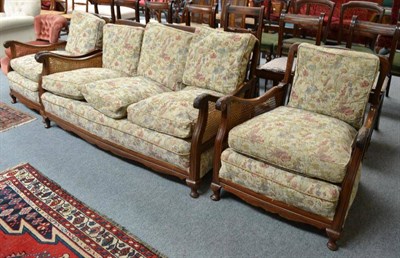 Lot 493 - A walnut framed three piece bergere suite with loose cushions