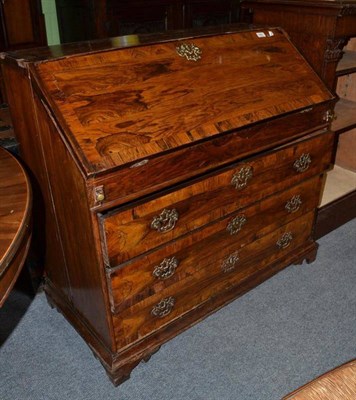 Lot 566 - A rosewood veneered and crossbanded bureau, in George III style, the fall enclosing a fitted...